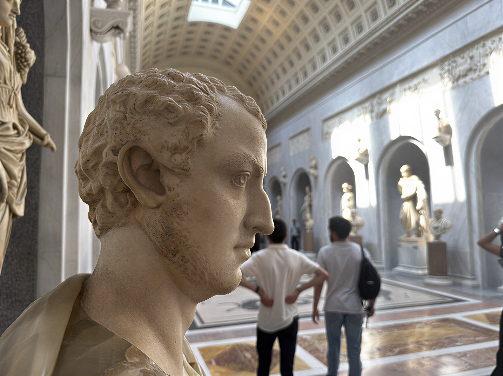 Buste antique dans la galerie des Trésors des Musées du Vatican, illuminé par la lumière naturelle, entouré de sculptures historiques.