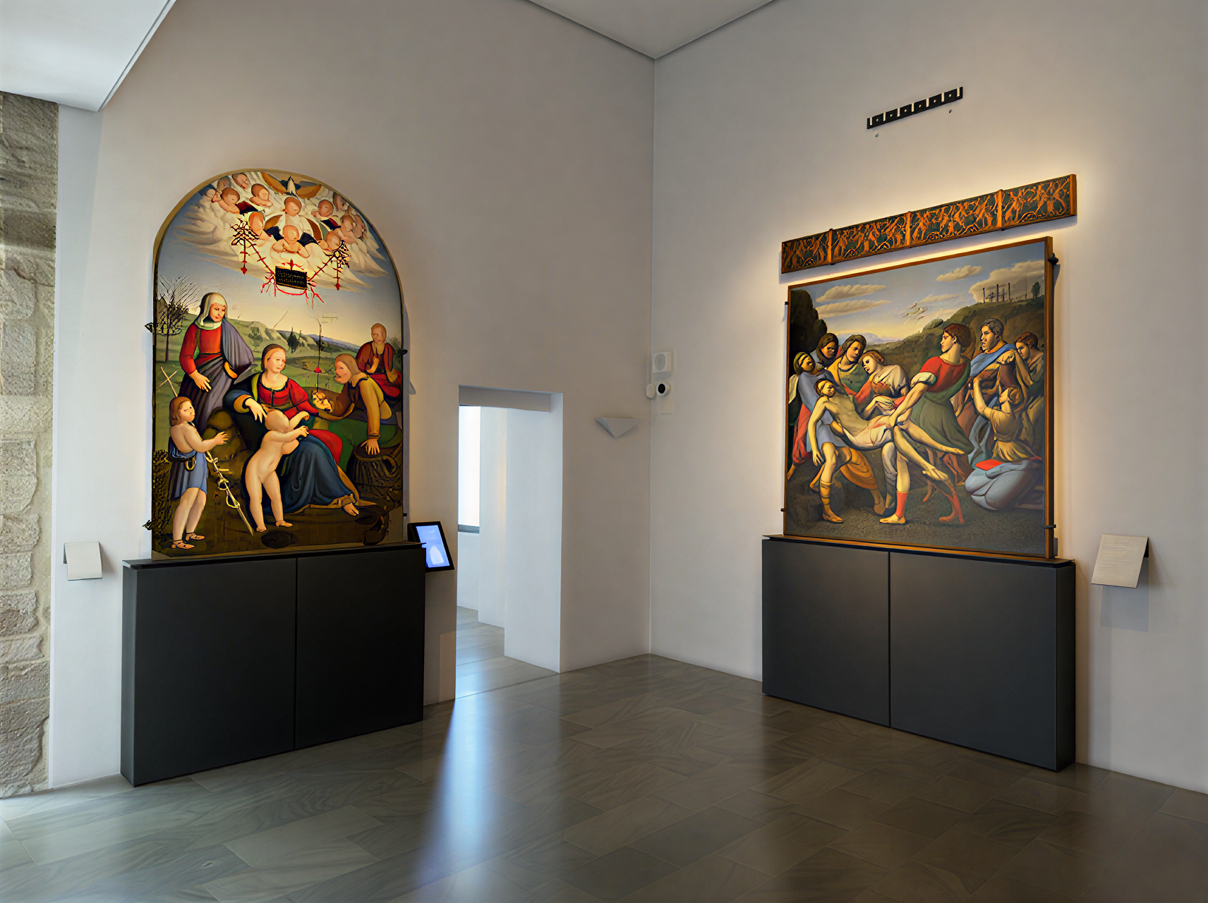 Intérieur de la Galleria Nazionale dell'Umbria montrant deux œuvres de la Renaissance italienne, illustrant la Vierge et l'Enfant ainsi qu'une scène de mise au tombeau.