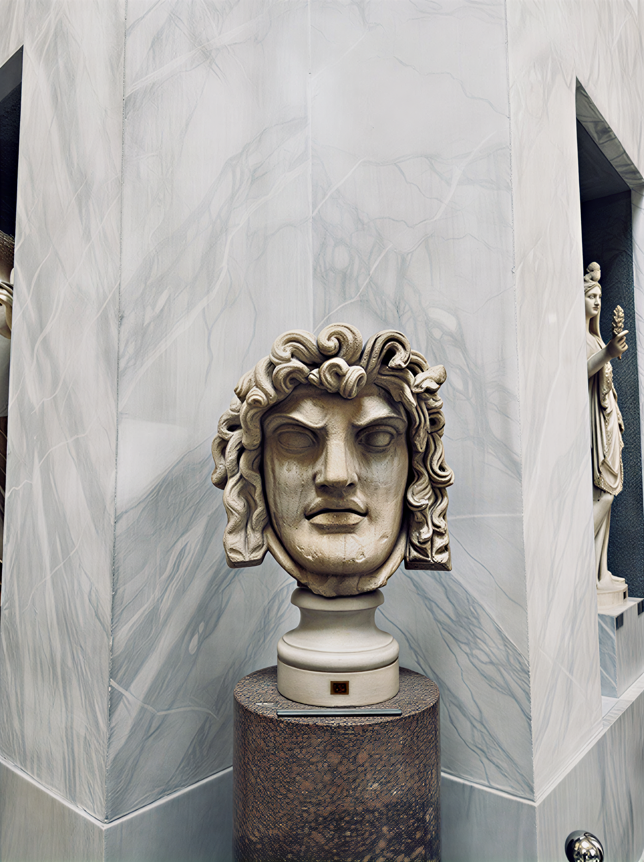 Sculpture antique de la tête de Méduse, exposée dans les Musées du Vatican, illustrant l'art et la mythologie de l'Antiquité, avec des détails saisissants qui captivent le regard.