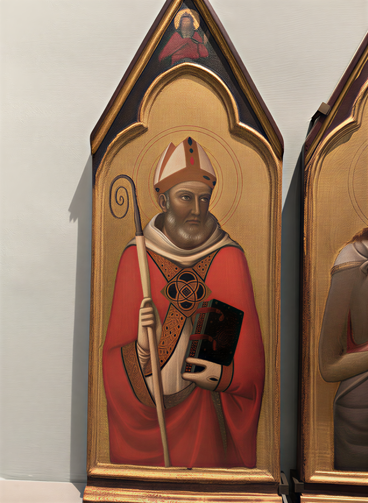 Détail d'un tableau représentant un saint évangéliste en robe rouge, mitre ornée et bâton pastoral, exposé à la Galleria dell'Accademia à Florence.