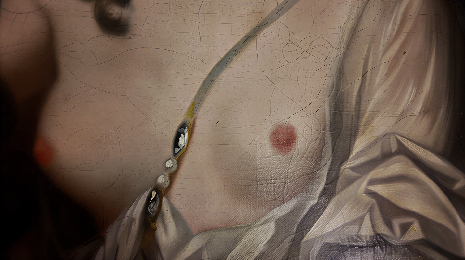 Détail d’une peinture montrant un drapé blanc et un bijou sur la poitrine d’une figure.