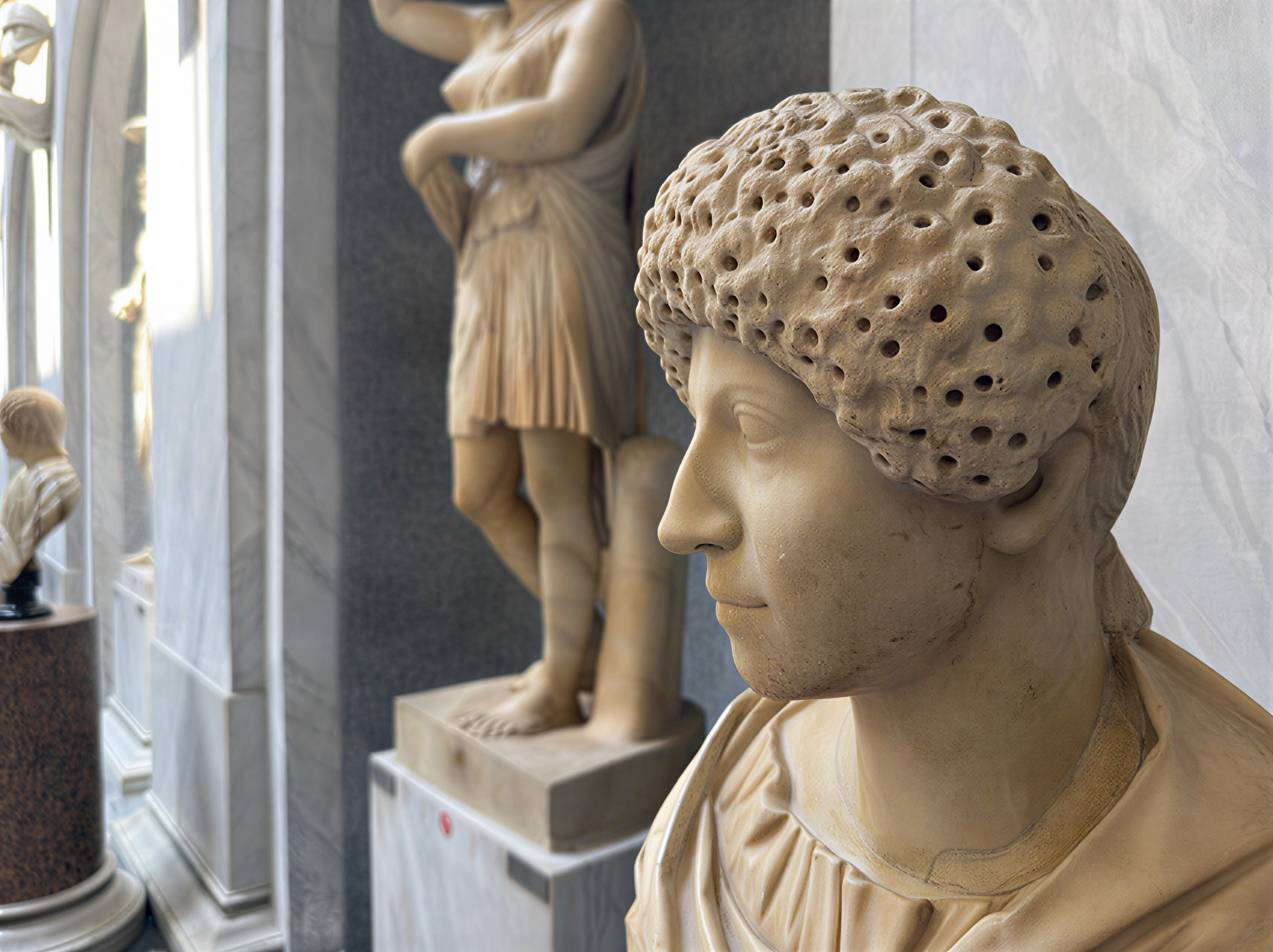 Détail d'une sculpture antique au sein des Musées du Vatican, mettant en avant la finesse des traits et la richesse artistique.