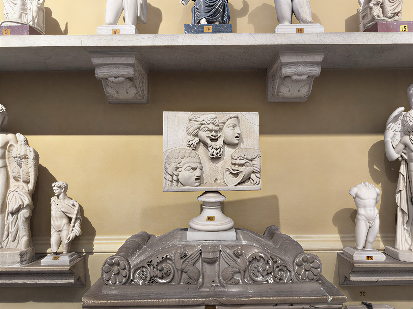 Relief sculpté antique représentant des visages, exposé aux Musées du Vatican, illustrant la maîtrise artistique de l'époque classique.