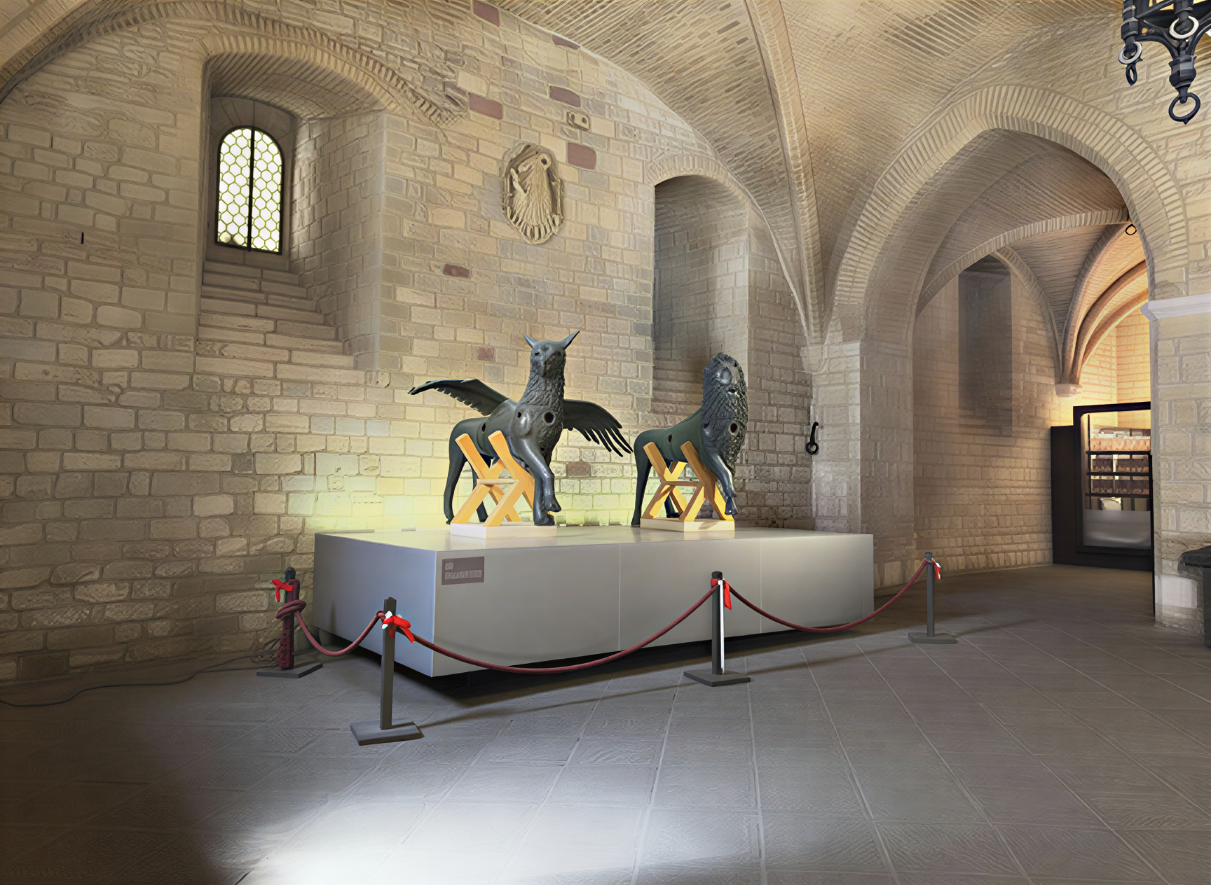 Photographie des sculptures d'un griffon et d'un lion dans la Galleria Nazionale dell'Umbria à Pérouse, illustrant la richesse de l'art de la Renaissance italienne dans un cadre historique majestueux.